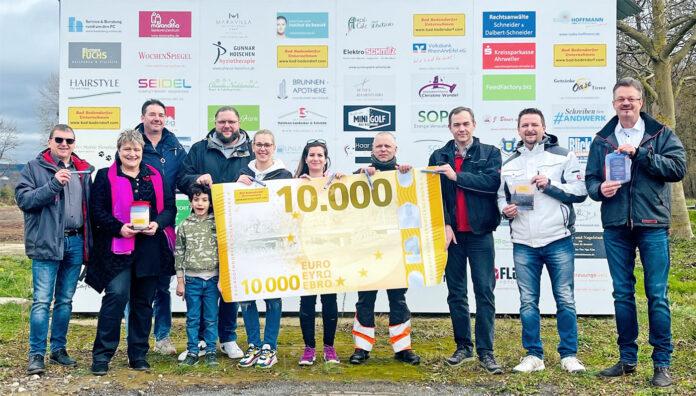 Vorstand des Unternehmervereins und die glücklichen Empfänger vor der Werbewand am völlig zerstörten Gelände des TC Bad Bodendorf.