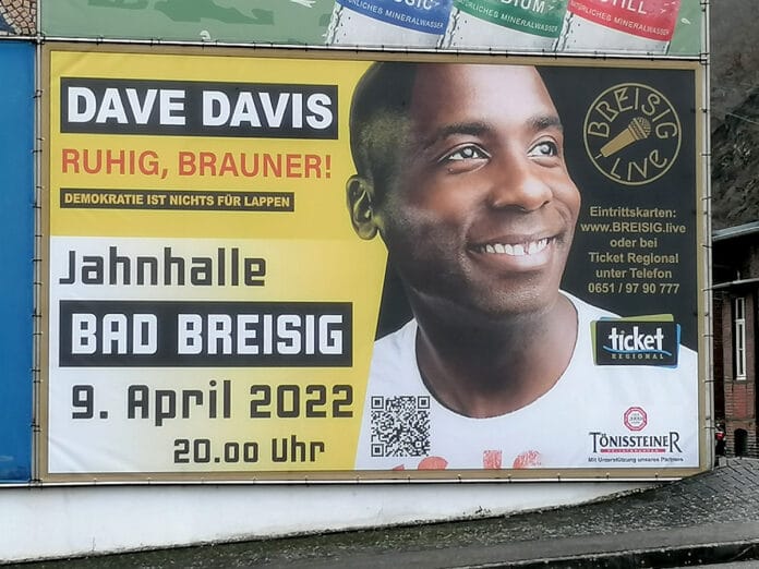 Die riesige Reklametafel an der B9 in Brohl überrascht: Dave Davis gastiert am 09.04.22 in der Jahnhalle Bad Breisig.