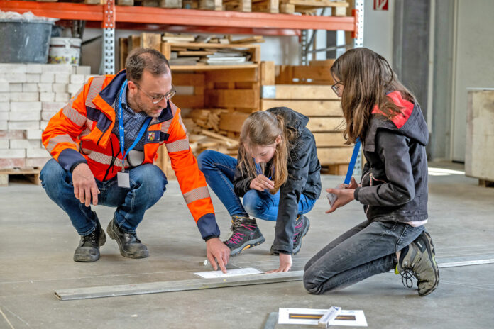 Die Teilnehmerinnen bei der Markierungsübung: Mit Plan, Winkel, Wasserwaage und Kreide ausgestatten markierten sie einen Abbiegepfeil.