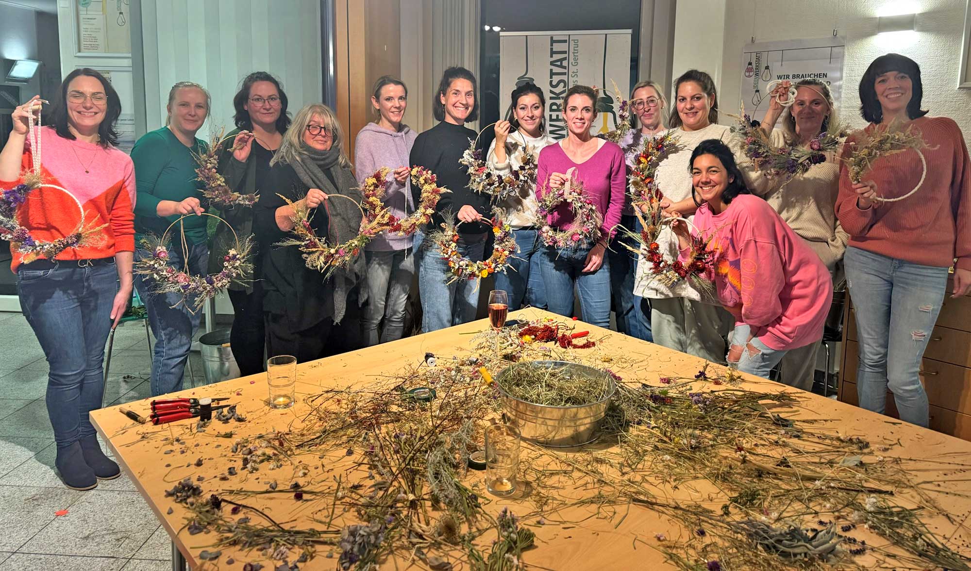 Strahlende Gesichter und stolze Kreationen: Teilnehmer präsentieren vollendete Trockenblumen-Werkstücke