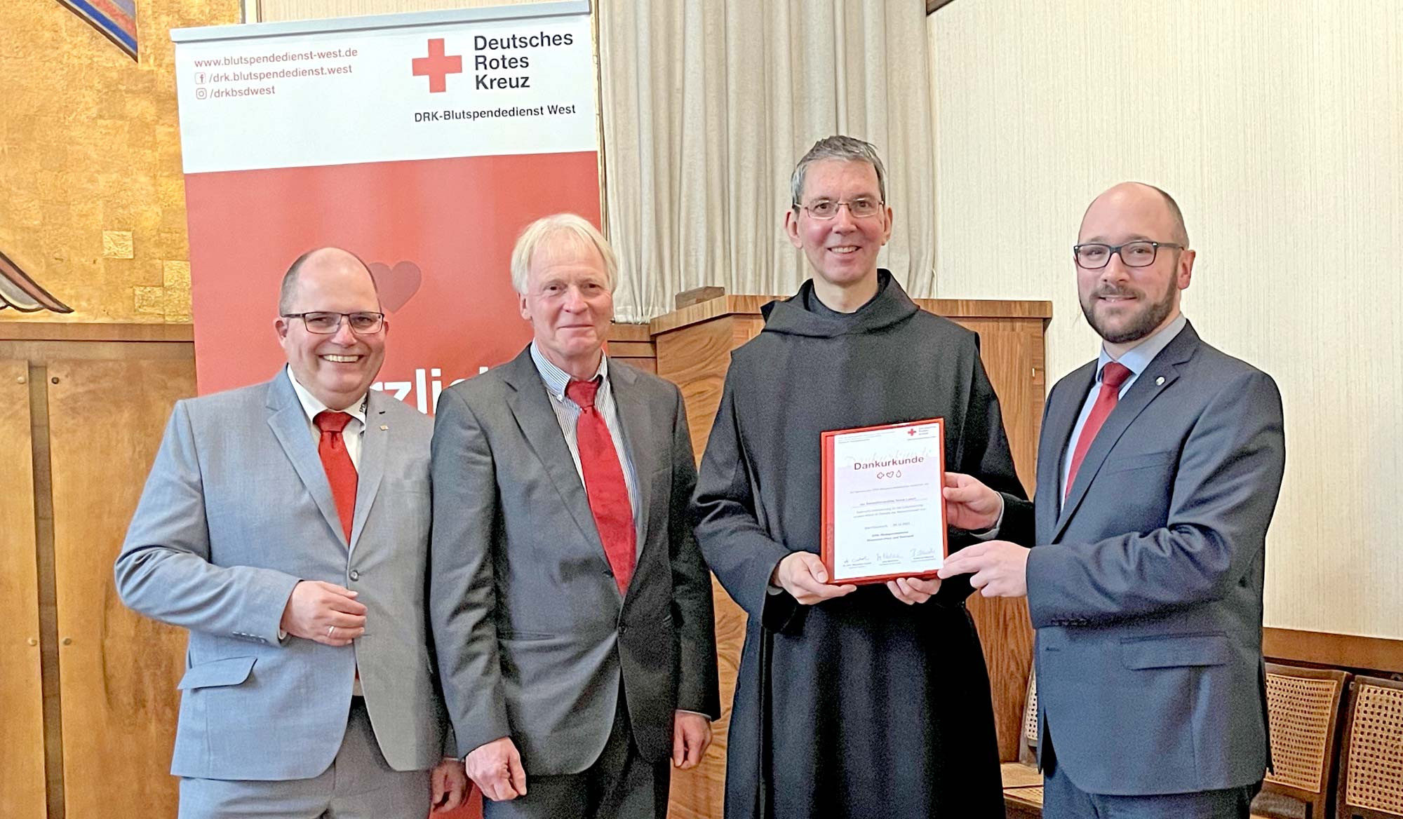 Für Benjamin Albrecht (Leiter Spendeorganisation DRK-Blutspendedienst Rheinland-Pfalz und Saarland, re.), Jörg Backhaus (Kaufmännischer Leiter DRK-Blutspendedienst Rheinland-Pfalz und Saarland, li.) und Franz-Josef Schneider (Gebietsreferent, 2. V. li.) war es eine Ehre, Pater Prior-Administrator Petrus Nowack OSB (2. V. re.) als Vertreter der Abtei für 60 Jahre Blutspende in der Benedektinerabtei eine Urkunde zu verleihen. (Foto: Astrid Zens / DRK-Kreisverband Ahrweiler e.V.)