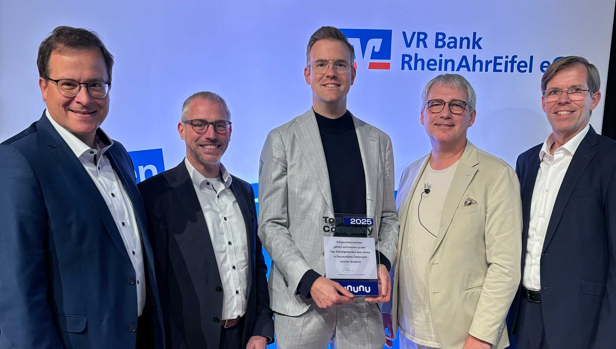 reuen sich über den Erhalt des kununu Top Comapany Awards (von links): Markus Müller (Vorstand der VR Bank RheinAhrEifel), Matthias Herfurth (Vorstand der VR Bank RheinAhrEifel), Dr. Gunnar Meier (Bereichsleiter Personal der VR Bank RheinAhrEifel)  Sascha Monschauer (Vorstandsvorsitzender der VR Bank RheinAhrEifel) und Michael C. Kuch (Vorstand der VR Bank RheinAhrEifel). Foto: Clara Elisa Stoffel I VR Bank RheinAhrEifel