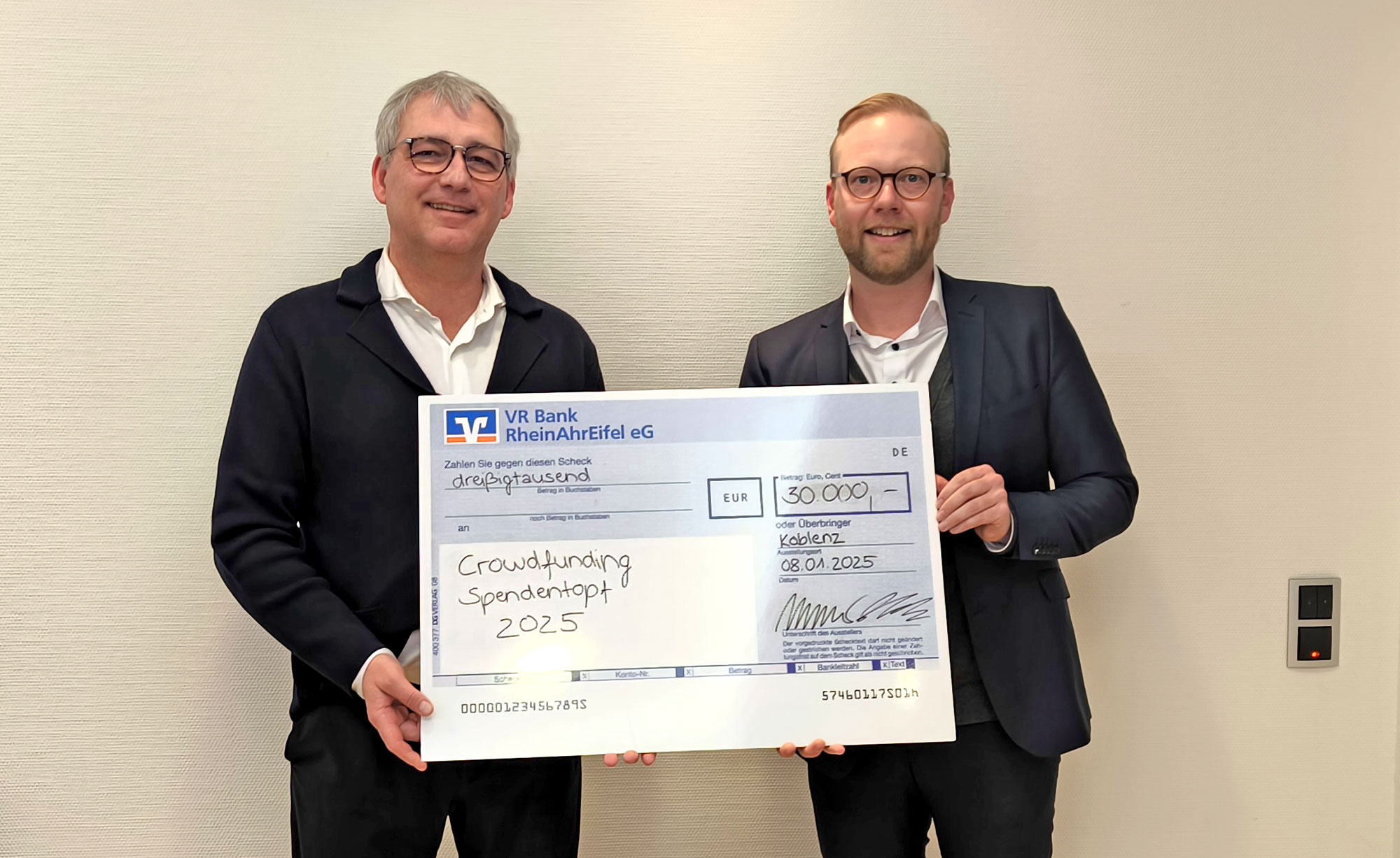 Sascha Monschauer (Vorstandsvorsitzender VR Bank RheinAhrEifel) und Jan-Erik Burkard (Marketingleiter VR Bank RheinAhrEifel) bei der symbolischen Scheckübergabe.